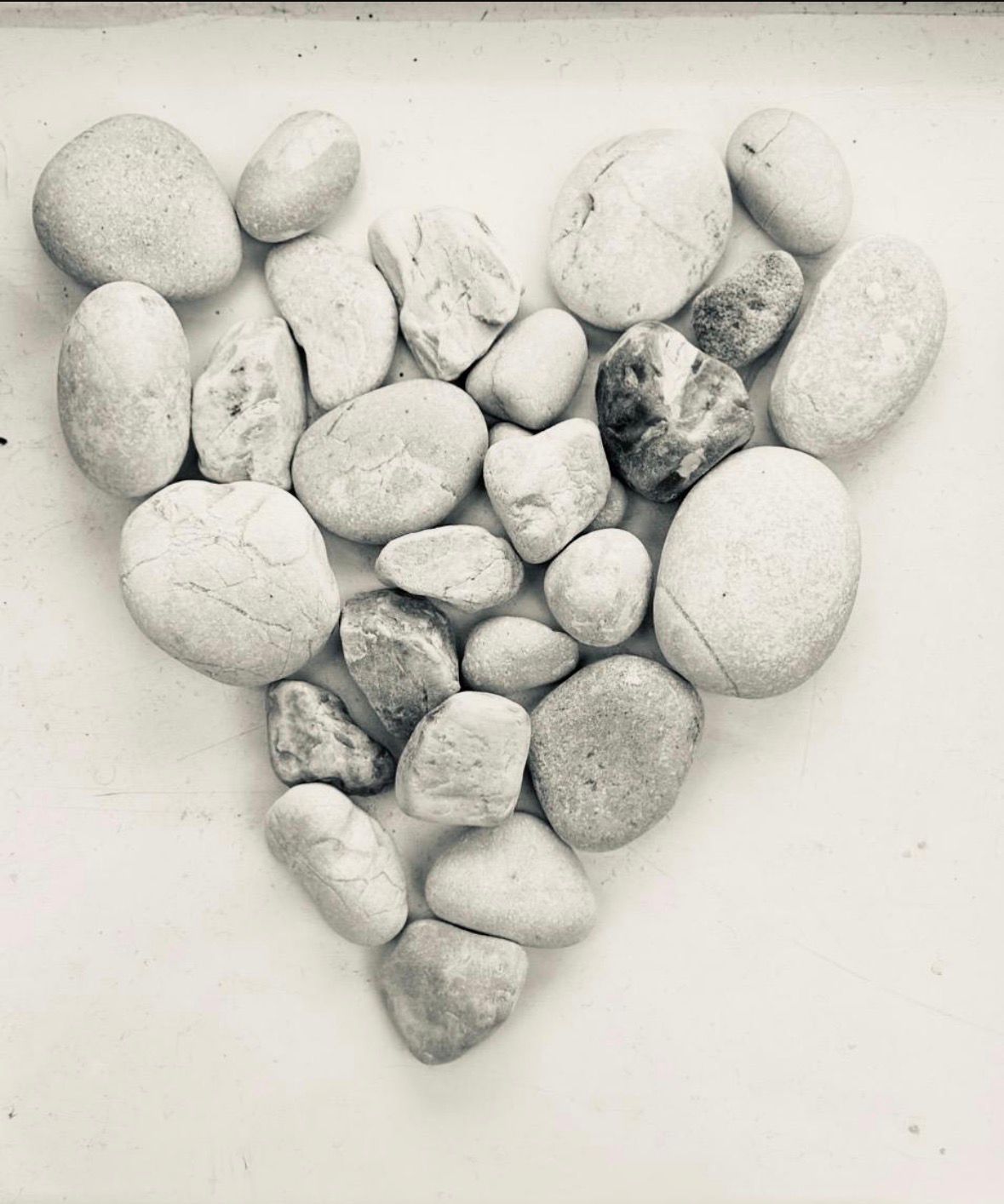 A heart shape gently formed from many small pebbles, each one different